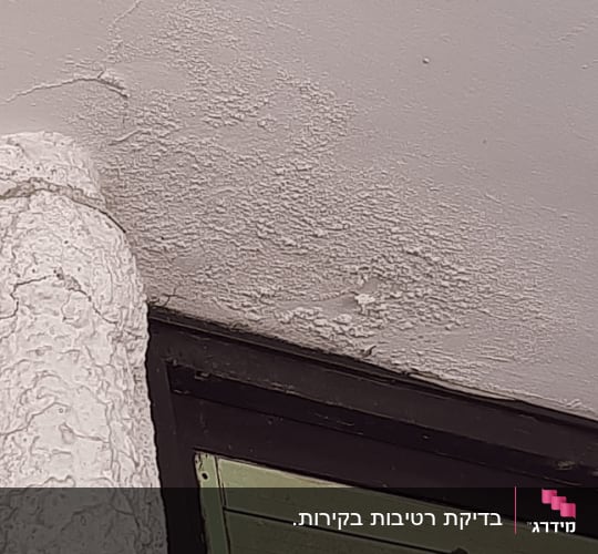 קיר עם סימני רטיבות ליד חלון